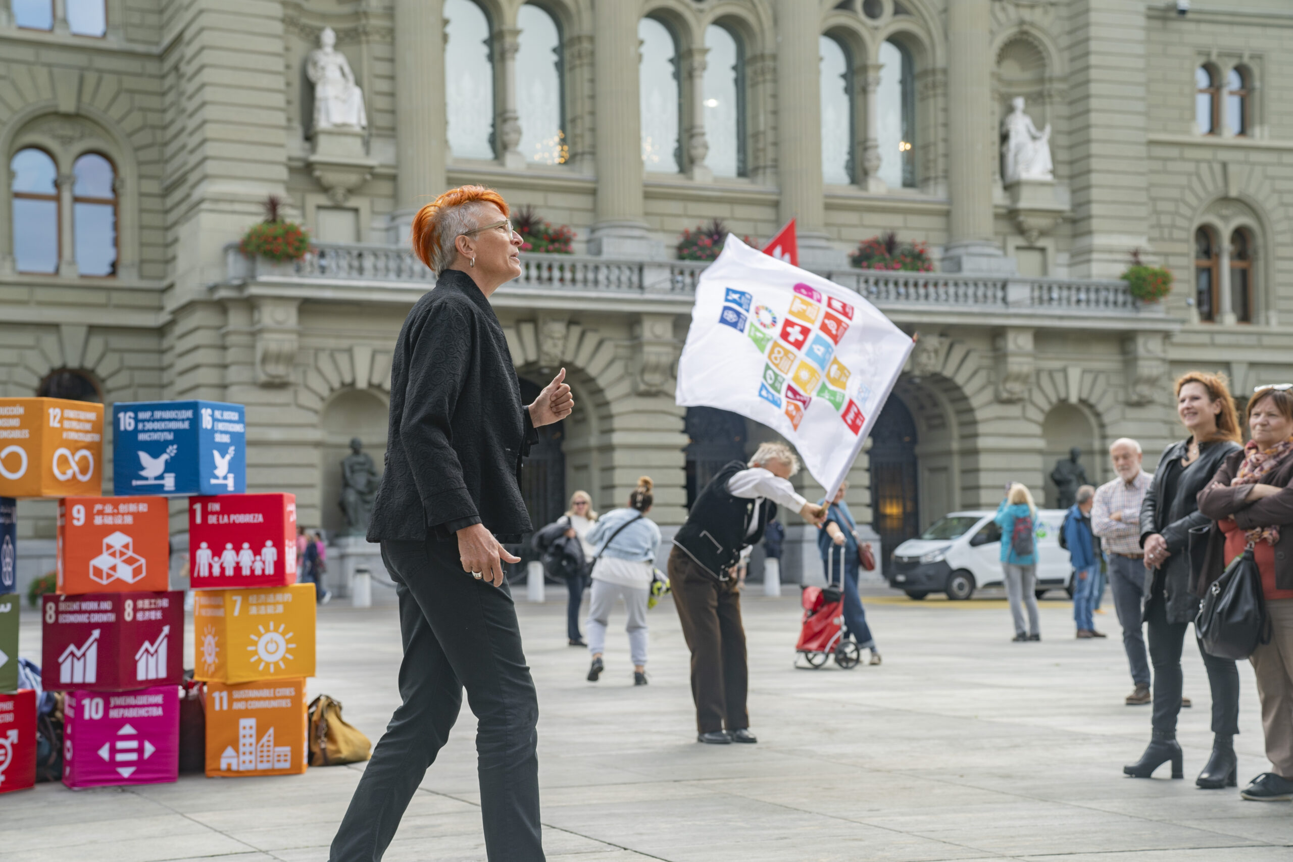 Autor:innen des Berichts mit SDG Würfel vor Bundeshaus